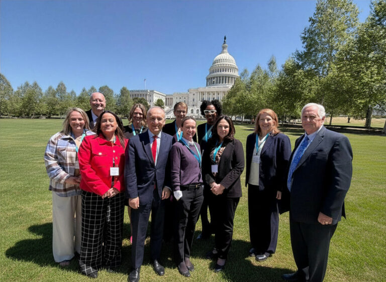 Group of individuals standing in front of the Capitol building in Washington DC.